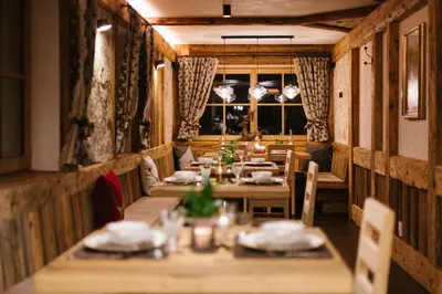 a restaurant with wooden tables and chairs and a window at Garni Fany in Colfosco