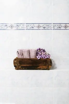 a wooden box with towels and flowers in a bathroom at Garni Fany in Colfosco