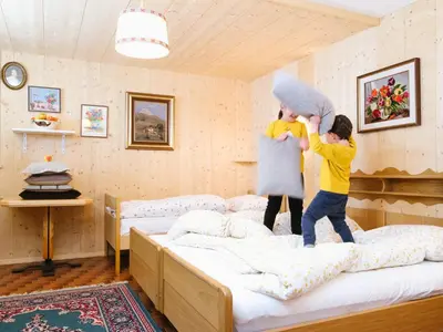 two children playing on a bed in a bedroom at Garni Fany in Colfosco
