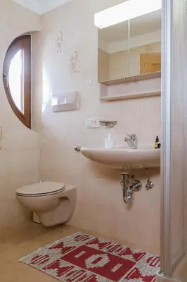 a bathroom with a toilet and a sink at Garni Fany in Colfosco