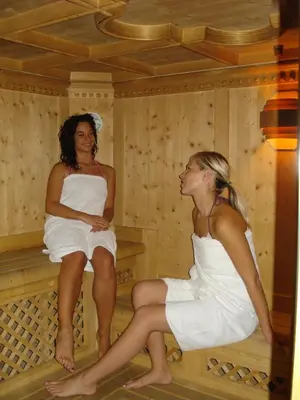 two women sitting in a sauna at Residence Holiday in Pozza di Fassa