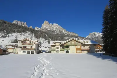 a group of buildings with footprints in the snow at Residence Holiday in Pozza di Fassa