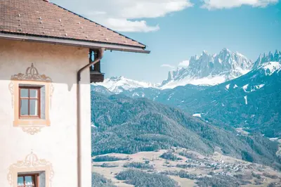 a wooden shed on a hill with a church at Kierhof Chalets in Velturno