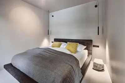 a bedroom with a large bed with yellow pillows at Stufels 7 Design Apartment with Brixen Card in Bressanone