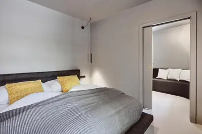 a bedroom with a bed and a mirror at Stufels 7 Design Apartment with Brixen Card in Bressanone