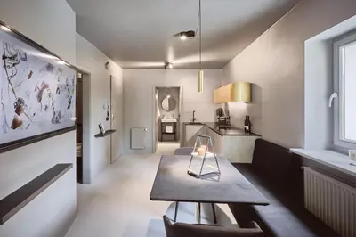 a living room with a table and a kitchen at Stufels 7 Design Apartment with Brixen Card in Bressanone