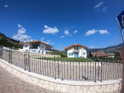 a white house with blue windows and a wall at Apartment in NOVELLA 41460 in Brez