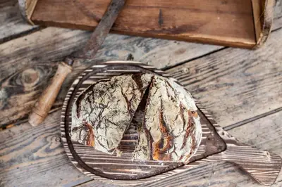 a piece of bread on a metal plate on a wooden floor at B&B Unterhabsbergerhof in Appiano sulla Strada del Vino