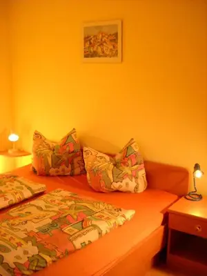 a bedroom with a bed and two pillows on it at Appartments Am Wiesenrand in Nova Ponente