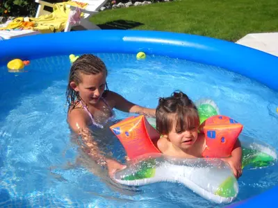 two children are playing in a swimming pool at Appartments Am Wiesenrand in Nova Ponente