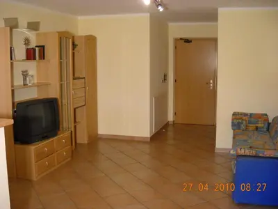 an empty living room with a tv and a couch at Appartments Am Wiesenrand in Nova Ponente