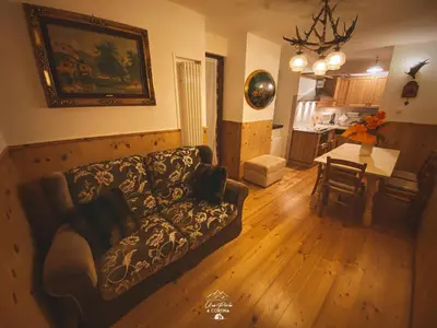 a living room with a couch and a dining room at Una Perla a Cortina in Cortina dʼAmpezzo