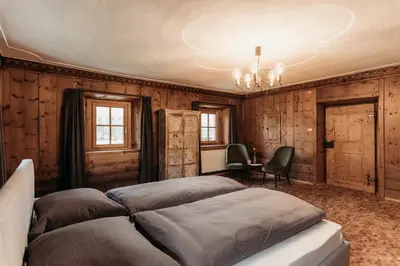 a bedroom with two beds and a table and chairs at Ban Hilba in Falzes