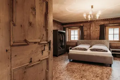 a bedroom with a bed and a wooden wall at Ban Hilba in Falzes