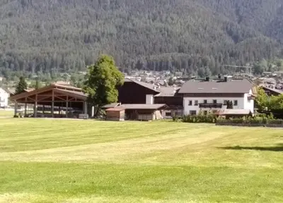 a large field of green grass with a house at Ban Hilba in Falzes