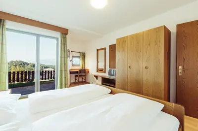 a hotel room with two beds and a balcony at Ferienwohnung Pension Stern in Aldino