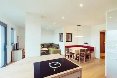 a kitchen and living room with a table and chairs at Ferienwohnung Pension Stern in Aldino