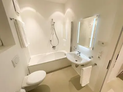 a white bathroom with a sink and a tub and a toilet at Lauben Suite Old Town Bolzano in Bolzano