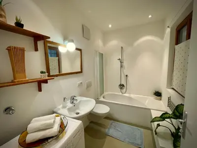a bathroom with a sink and a toilet and a bath tub at Lauben Suite Old Town Bolzano in Bolzano