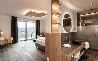 a hotel room with a bathroom with a bed and a sink at Pippos Mountain Lodge in Soprabolzano