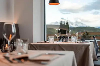 a table with wine glasses and a view of a mountain at Pippos Mountain Lodge in Soprabolzano