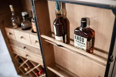 two bottles of alcohol on a shelf in a cabinet at Pippos Mountain Lodge in Soprabolzano