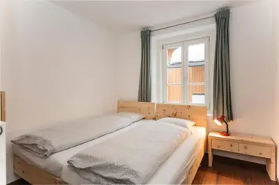 a bed in a bedroom with a window and a table at vedla posta in Badia