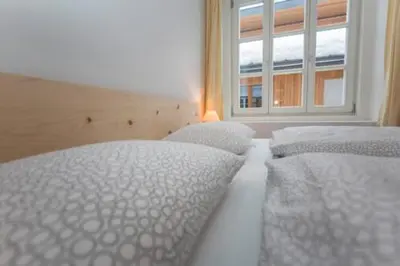 two white beds in a room with a window at vedla posta in Badia