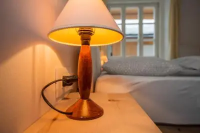 a lamp sitting on a table next to a bed at vedla posta in Badia