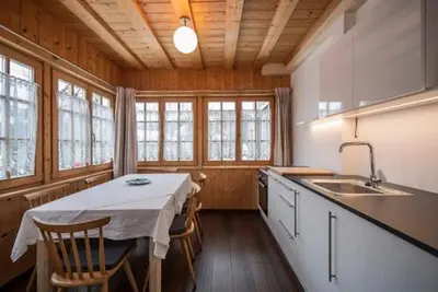 a kitchen with a table with chairs and a sink at vedla posta in Badia