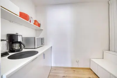 a white kitchen with a microwave and a counter at HOMESTWENTY3 - Home five in Caldaro