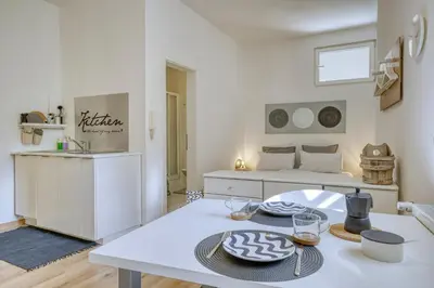 a white living room with a table and a bed at HOMESTWENTY3 - Home five in Caldaro