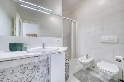 a white bathroom with a sink and a toilet at HOMESTWENTY3 - Home five in Caldaro