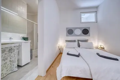 a white bedroom with a large bed and a sink at HOMESTWENTY3 - Home five in Caldaro