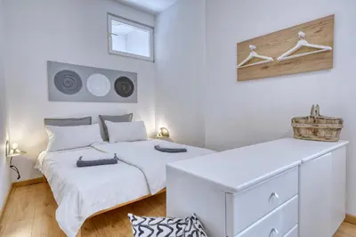 a white bedroom with two beds and a window at HOMESTWENTY3 - Home five in Caldaro