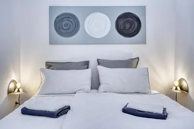 a bedroom with a white bed with two lamps at HOMESTWENTY3 - Home five in Caldaro