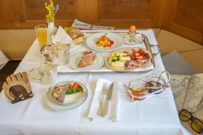 a white table with plates of food on it at Weisses Rössl in Caldaro