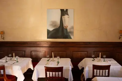 a dining room with two tables with white tablecloths at Weisses Rössl in Caldaro