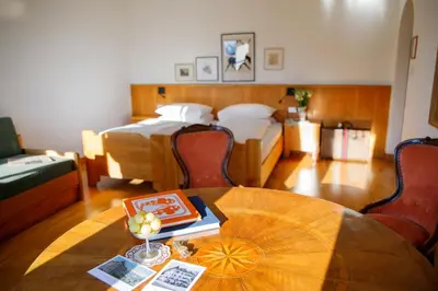 a room with a table and a bed and a room with a bed at Weisses Rössl in Caldaro