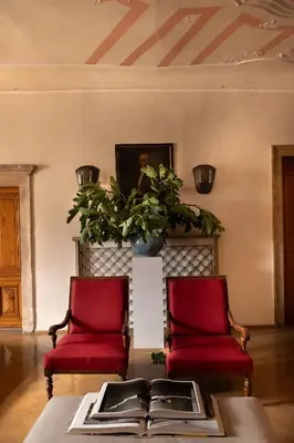 two red chairs in a living room with a table at Weisses Rössl in Caldaro