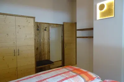 a bedroom with a bed and a wooden cabinet at Schmalzlhof in Siusi