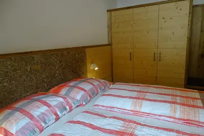 a bedroom with a bed and a cabinet at Schmalzlhof in Siusi