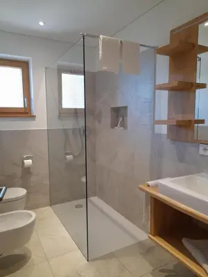 a bathroom with a shower and a toilet and a sink at Schmalzlhof in Siusi