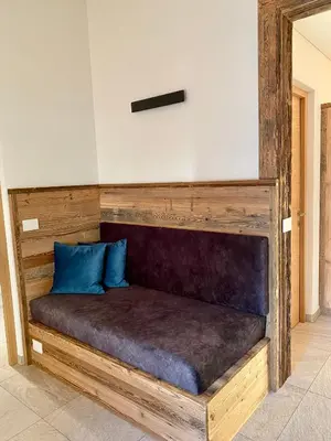 a wooden bed with blue pillows on top of it at Schmalzlhof in Siusi