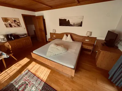a small bedroom with a bed and a desk at Haus Bergfrieden Seiser Alm in Siusi