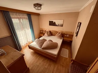 a bedroom with a bed with two pillows on it at Haus Bergfrieden Seiser Alm in Siusi