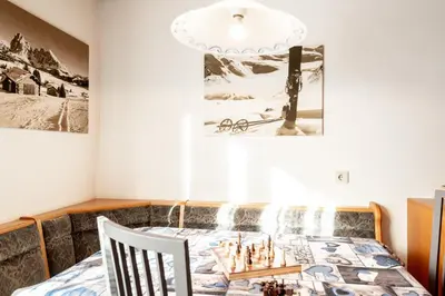 a dining room with a table with chessetts on it at Haus Bergfrieden Seiser Alm in Siusi