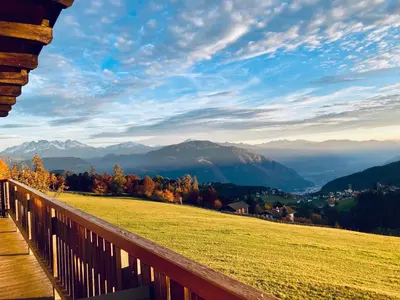 a view from a wooden balcony of a field and mountains at Rempphof in San Genesio Atesino