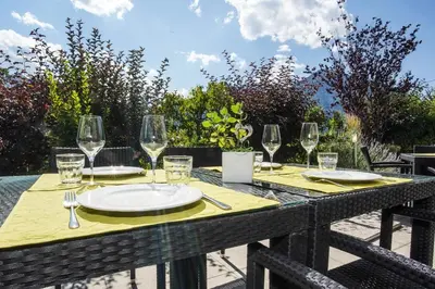 a table with wine glasses and a plate on it at Residence Bar Pizzeria Sylvanerhof in Naz-Sciaves