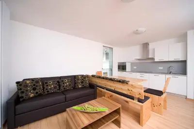 a living room with a black couch and a table at Residence Bar Pizzeria Sylvanerhof in Naz-Sciaves
